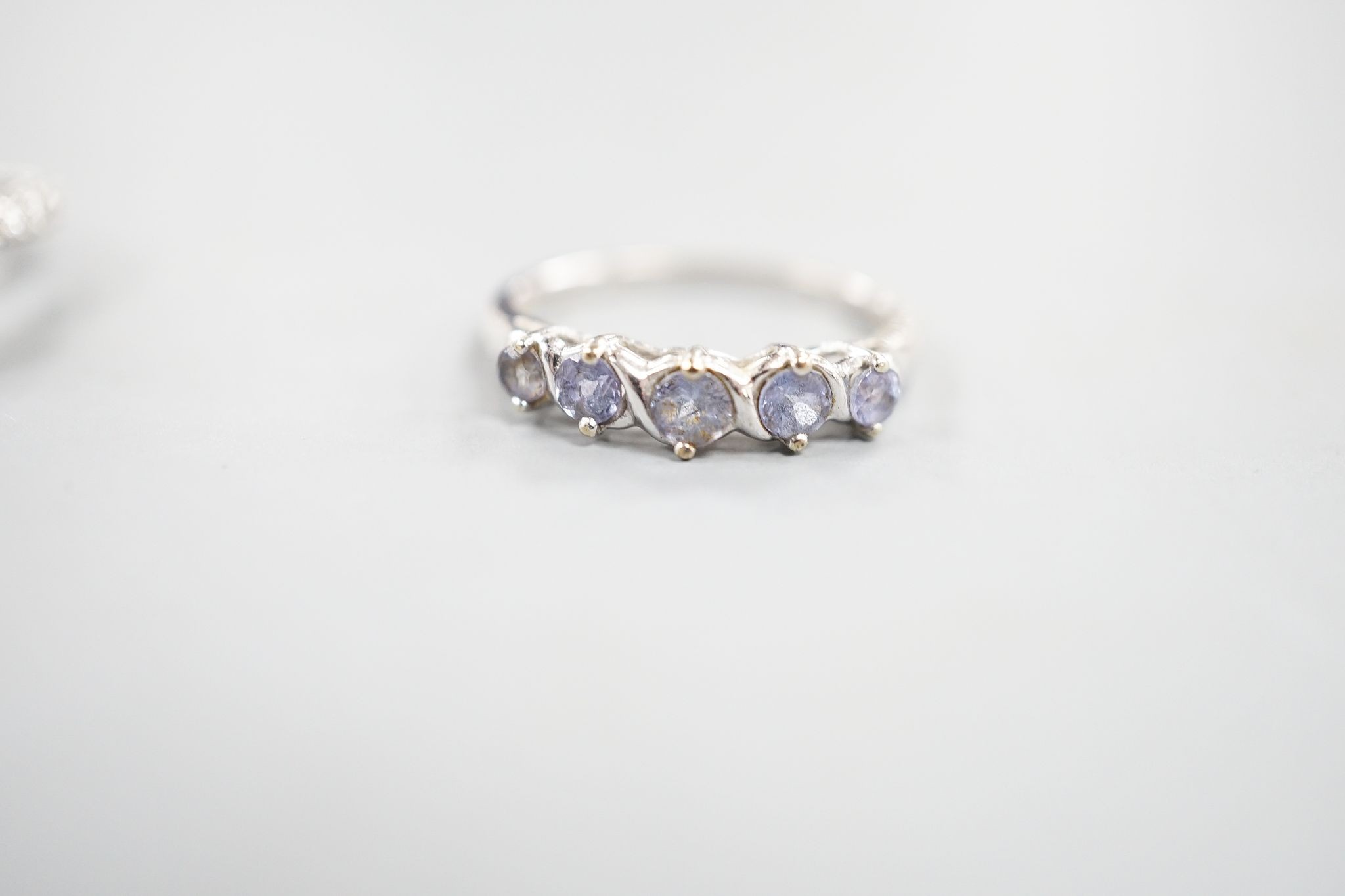 Two modern 18k white metal, tanzanite and diamond set dress rings, size J, gross 8.3 grams and a modern 9ct white gold and gem set ring, gross 2 grams.